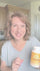 Woman holding a container of Brain Optimal in a kitchen setting