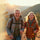 Two people hiking in a mountainous area with backpacks and walking sticks.